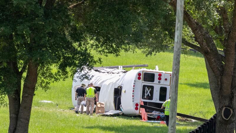 Policía y socorristas inspeccionan un autobús que se volcó tras chocar con una camioneta...
