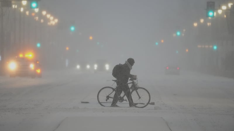 Una persona empuja una bicicleta en medio de una tormenta invernal en Filadelfia el 25 de...