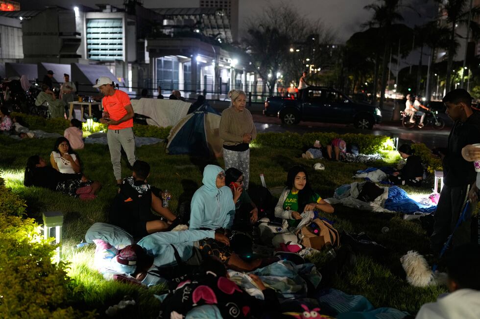 La gente se prepara para pasar la noche al aire libre después de que terremotos sacudieran...