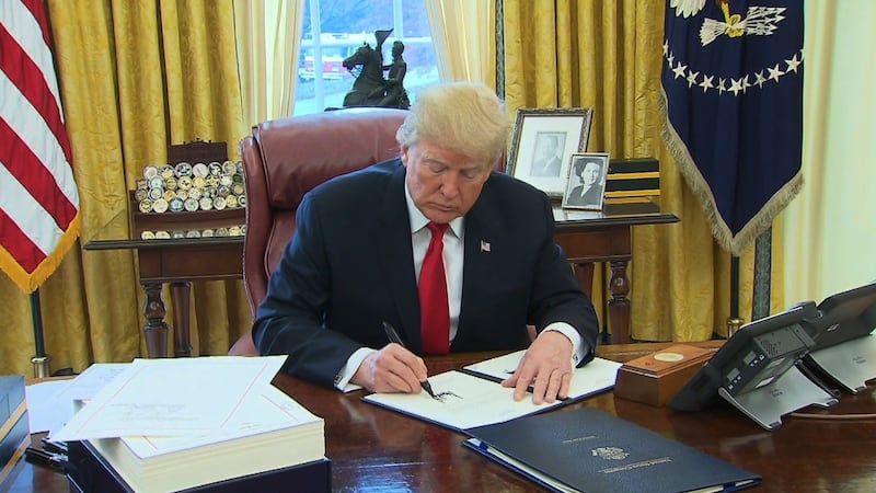 FILE -- President Donald Trump signing at White House.