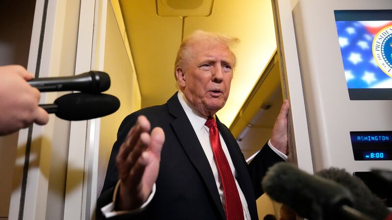 El presidente Donald Trump habla con los reporteros a bordo del Air Force One, el domingo 19...