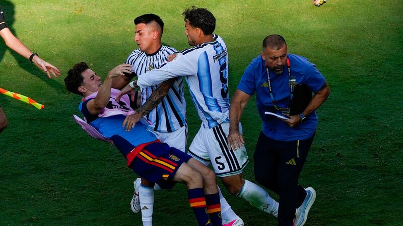 El jugador español Gavi, a la izquierda, es empujado en un choque con el jugador argentino...