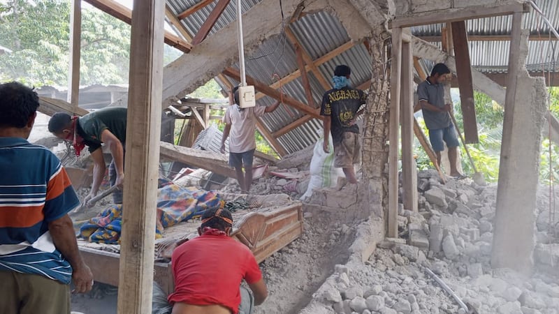 Varias personas retiran escombros de una casa destruida por un terremoto, el sábado 15 de...